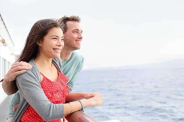 Ein Paar an Deck auf einer Fähre nach Korsika und blickt auf das Meer
