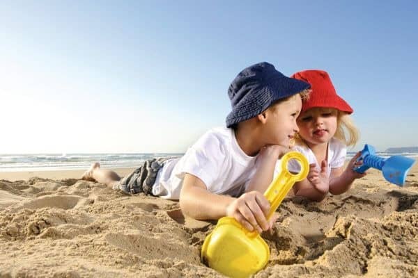 2 Kinder mit Spielzeug am Strand von Korsika