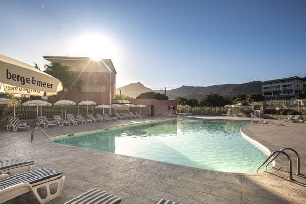 Blick auf den Pool mit Liegen im Ferienhotel Maristella auf Korsika