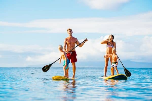 Familie beim Stand-Up-Paddling auf ruhiger See