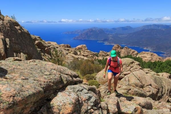 Frau beim Wandern im Gebirge oberhalb des Golf von Porto auf Korsika