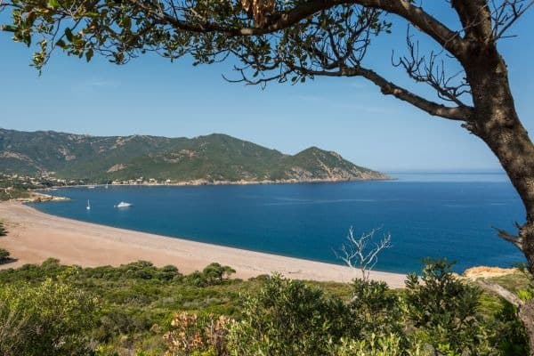 Sandstrand und blaues Meer in der Bucht von Galéria auf Korsika