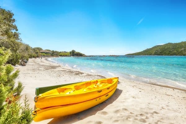 Gelbes Kajak am traumhaften Strand und türkisblaues Meer am Santa Giulia Beach auf Korsika